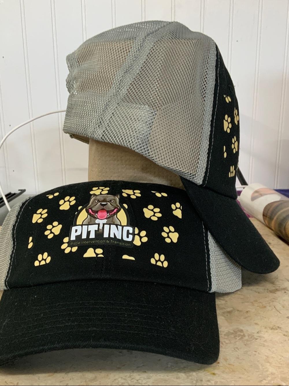Supports a local rescue! PIT INC logo Black & Gray Paw Print Trucker Hat